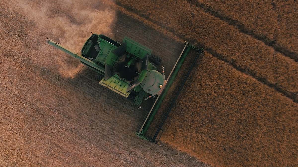 dirt road green farming equipment on brown field gravel
